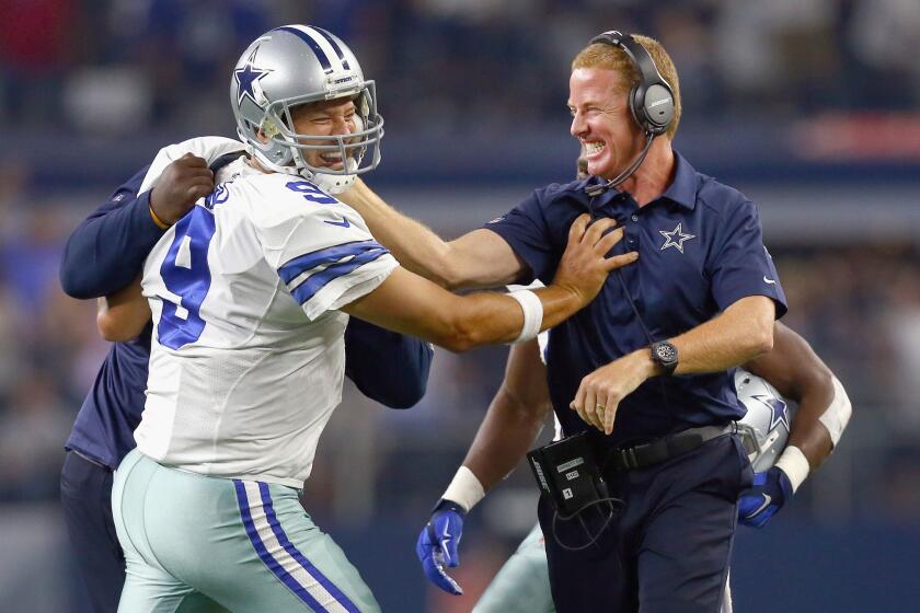 Cowboys quarterback Tony Romo celebrates with Coach Jason Garrett after Dallas scored the game-winning touchdown against the Giants.