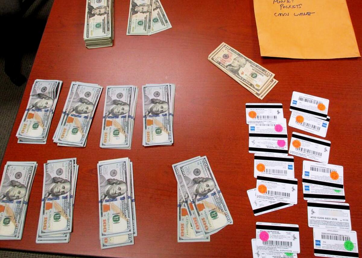 Cash and bank cards are laid out on a red-wood table.