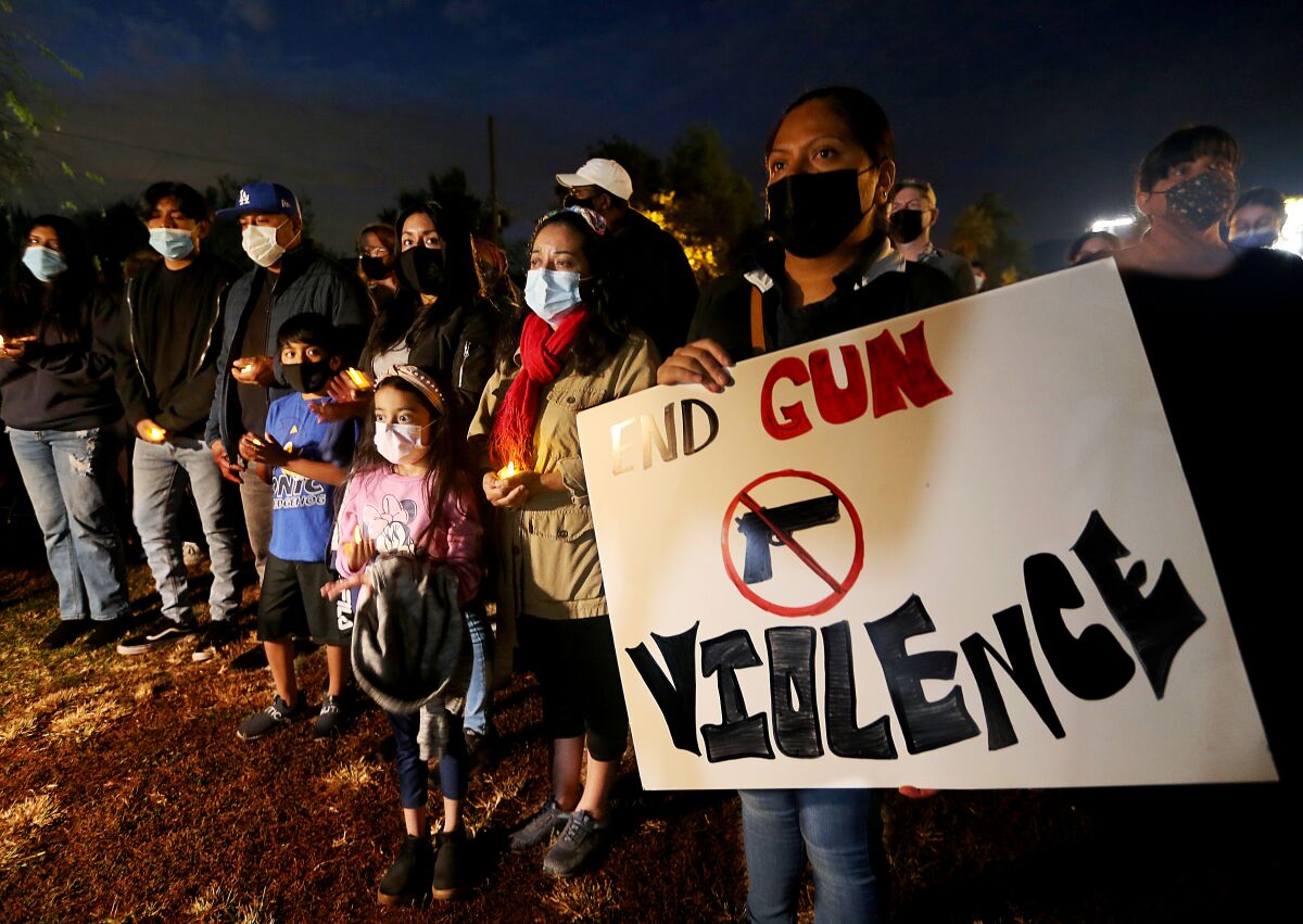 One person in a crowd holds a sign that reads "End gun violence" 