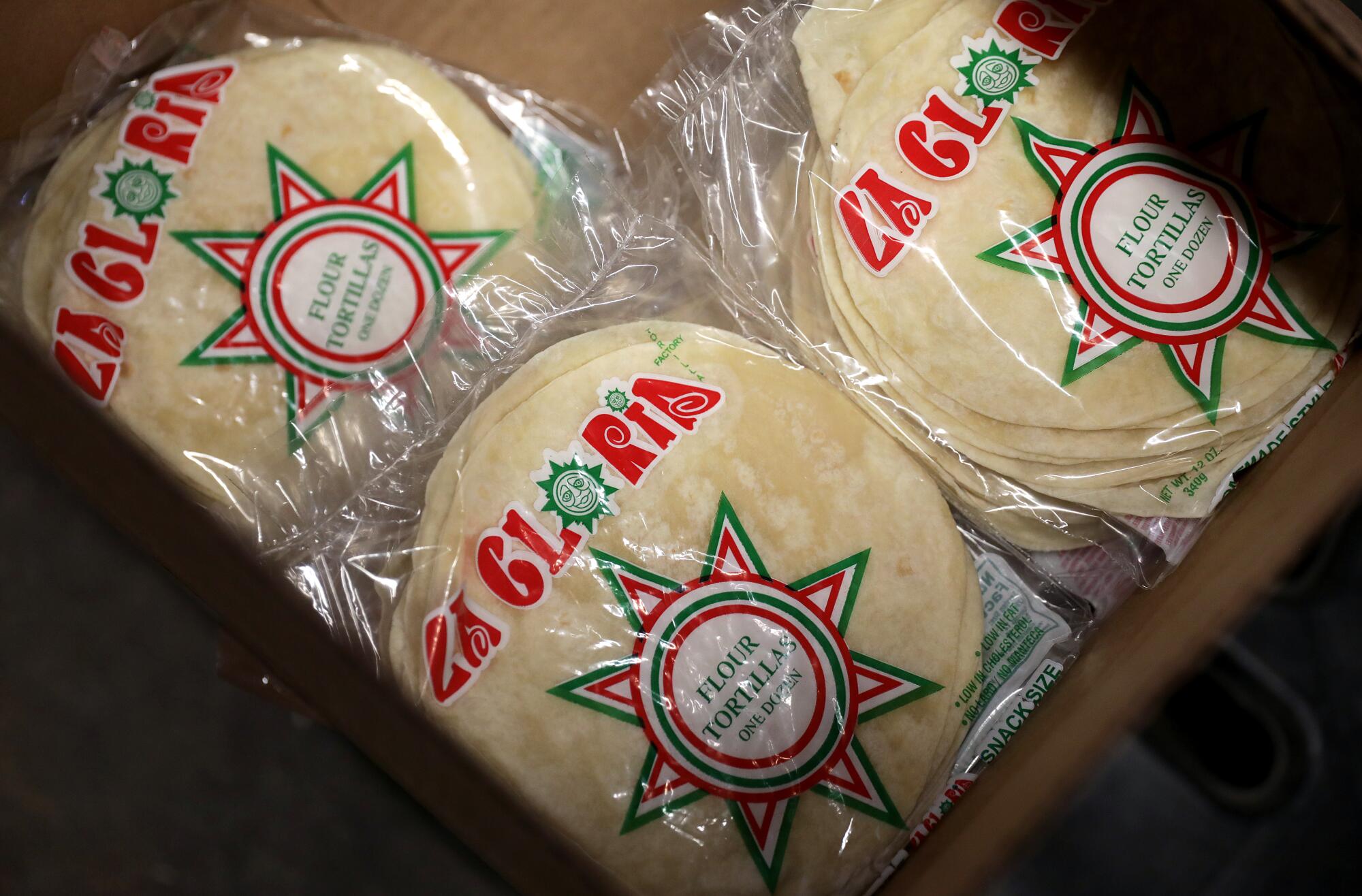 Flour tortillas inside bags that say "La Glorida" with festive designs