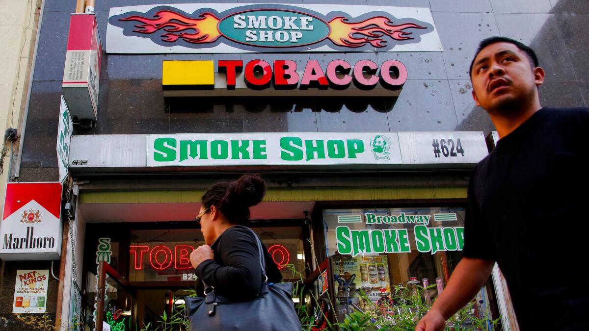 LOS ANGELES, CALIFORNIA-APRIL 14, 2015: California wants to rage the minimum age to buy tobacco products to 21. Big tobacco companies are readying for legal battle to block the legislation. Pedestrians pass by a smoke shop on Broadway in Downtown Los Angeles. (Michael Robinson Chavez/Los Angeles Times)