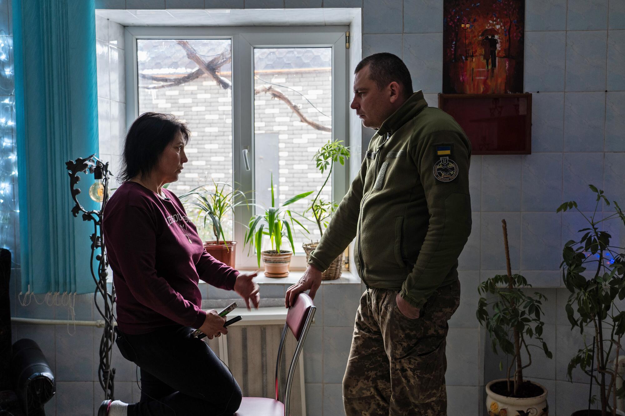 Olena Kovalyk speaks to Serhiy, a Ukrainian civilian-military liaison officer, in her home in Myrolyubivka.