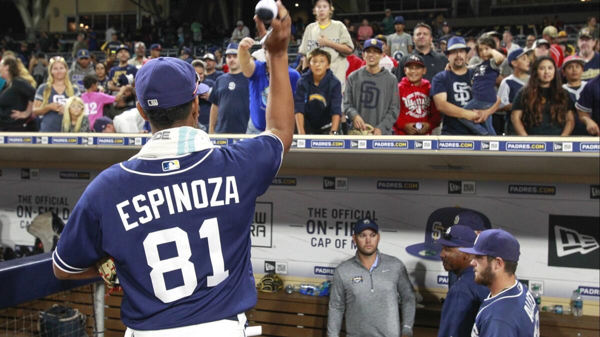 Padres pitcher Anderson Espinoza tosses a ball he just autographed back to a fan after the Padres beat the Texas Rangers during the Padres Futures Game at Petco Park on Friday, Oct. 7, 2016.