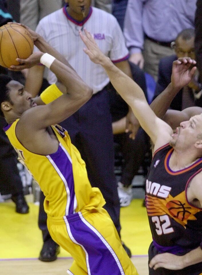 Kobe Bryant moves to make a winning shot even with the Phoenix Suns' Jason Kidd's hand in his face.