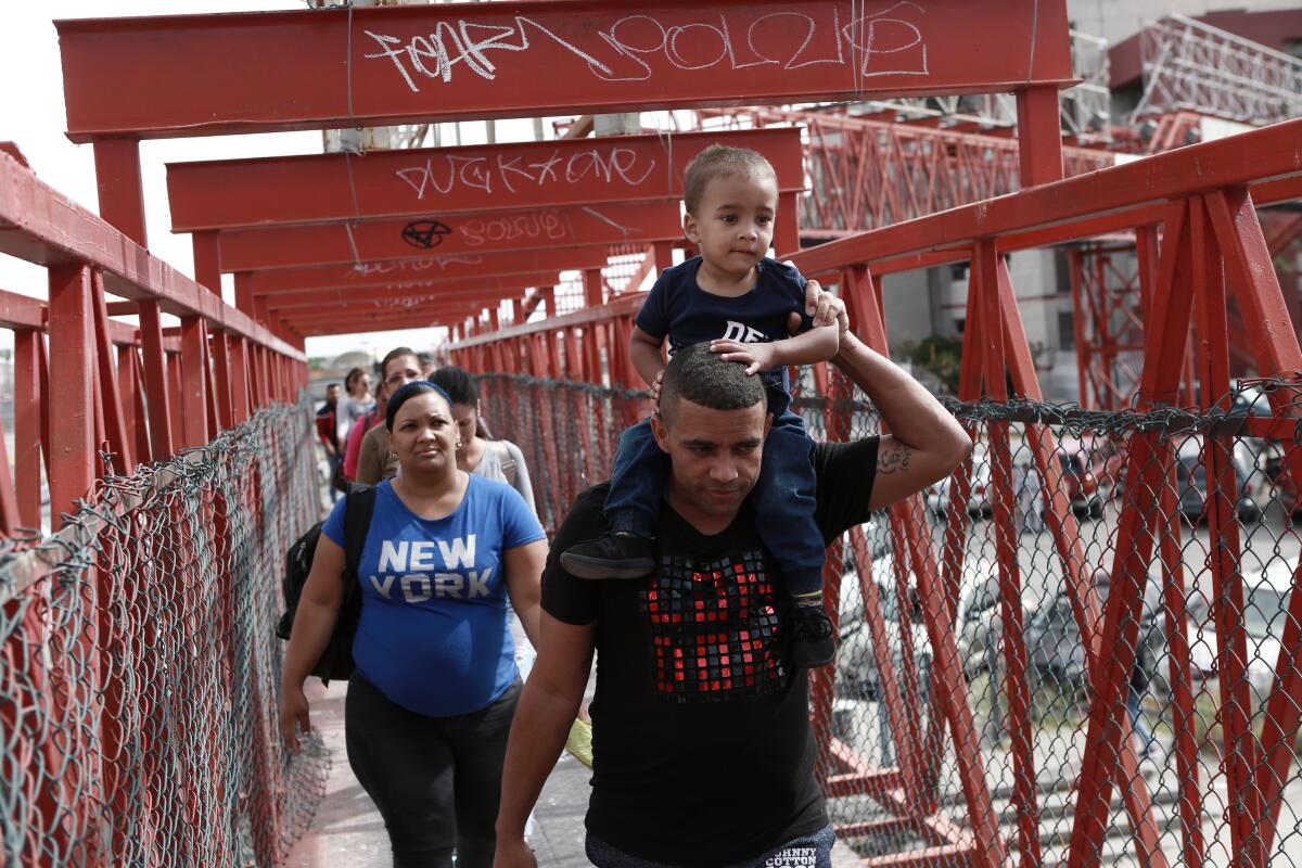 En esta imagen del 29 de abril de 2019, migrantes cubanos son escoltados por las autoridades migratorias mexicanas en Ciudad Juárez, mientras cruzan el puente internacional Paso del Norte para ser procesados como solicitantes de asilo en el lado estadounidense de la frontera. (AP Foto/Christian Torres, Archivo)