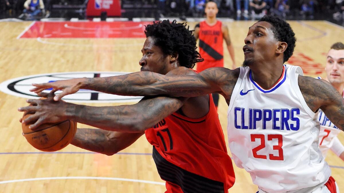 Clippers guard Lou Williams and Portland forward Ed Davis reach for a rebound on Jan. 30.
