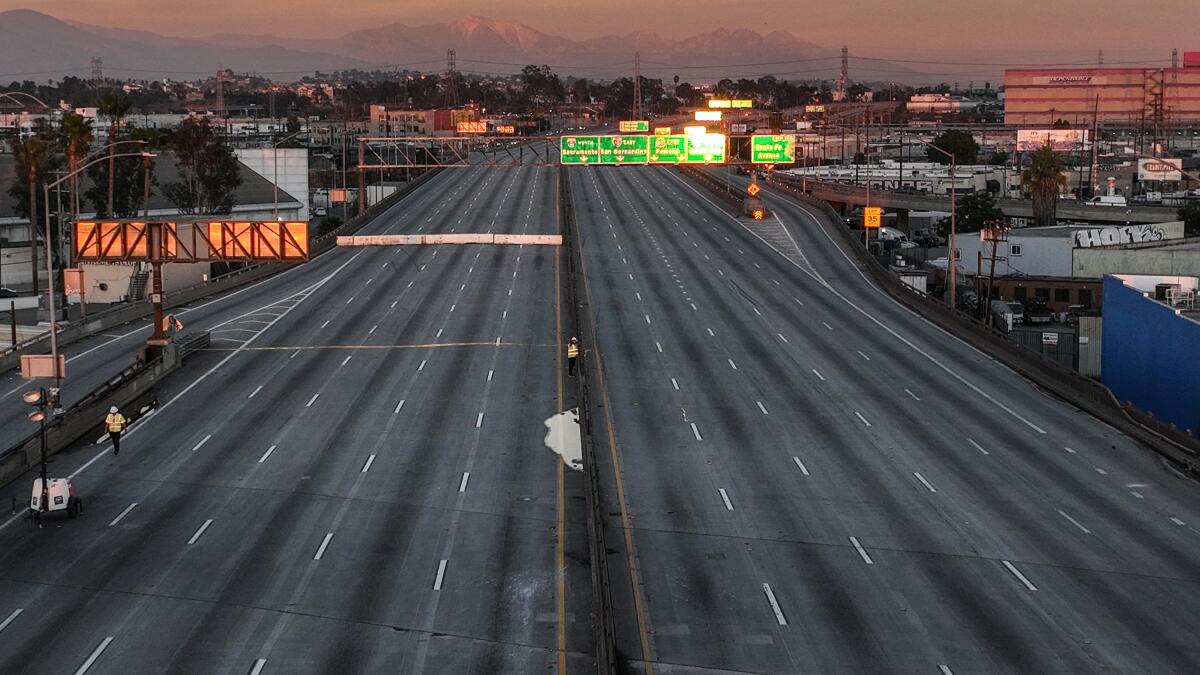 CalTrans workers walk along the closed stretch of the 10 Freeway.