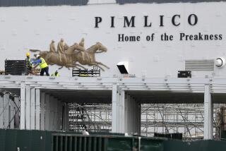 A crew works on putting up a platform near the main entrance at Pimlico Race Course, Friday, May 15, 2020, in Baltimore. Horse racing is in a state of transition at a time usually reserved for Triple Crown season. The Preakness would have been run Saturday, May 16, 2020, in Baltimore. But Pimlico Race Course and many tracks across North America remain dark because of the coronavirus pandemic. (AP Photo/Julio Cortez)