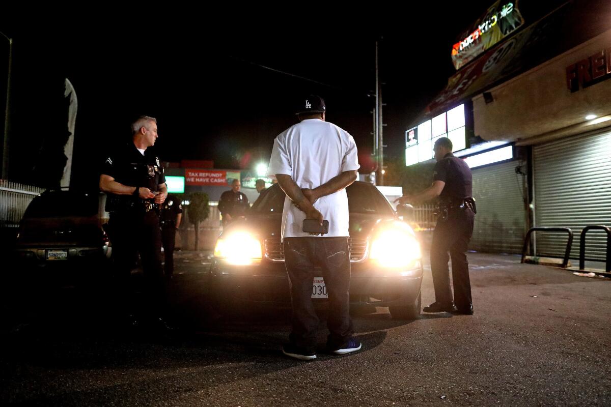 LAPD Metropolitan Division officers Mike Burtner, left, and Erick Sinkovits detain a suspect.