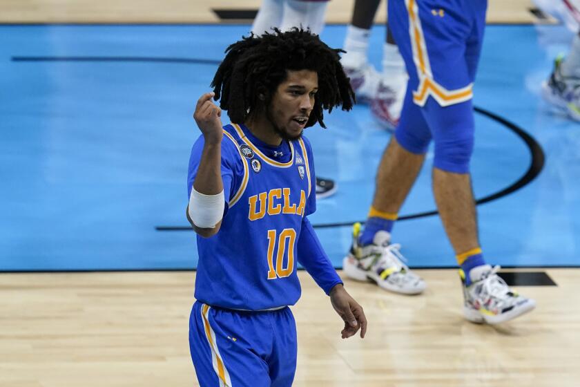 UCLA guard Tyger Campbell (10) celebrates after making a basket during the first half of a men's Final Four NCAA college basketball tournament semifinal game against Gonzaga, Saturday, April 3, 2021, at Lucas Oil Stadium in Indianapolis. (AP Photo/Michael Conroy)