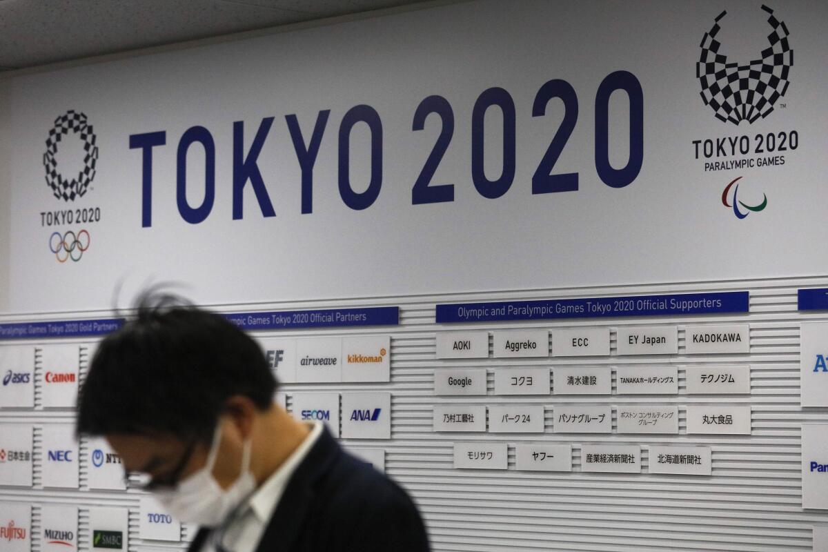 Un periodista aguarda por el inicio de una rueda de prensa del comité organizadores de los Juegos Olímpicos de Tokio 2020, el martes 24 de marzo de 2020. El COI anunció el aplazamiento de los Juegos a 2021 debido a la pandemia del coronavirus. (AP Foto/Jae C. Hong)