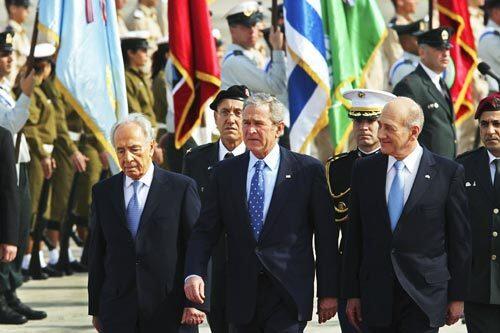 President Bush is flanked by Israeli Prime Minister Ehud Olmert, right, and President Shimon Peres as they walk down the red carpet during an official welcoming ceremony at Israel's Ben Gurion Airport near Tel Aviv.