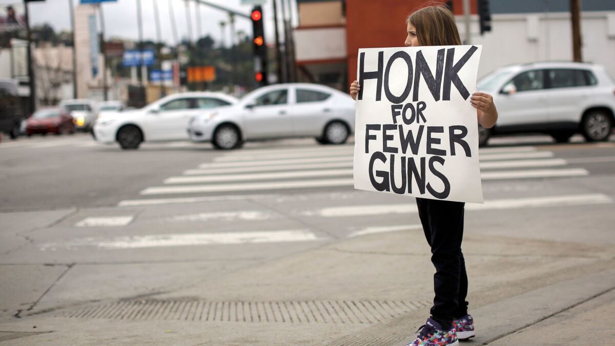 Daisy Simard, 9, holds a sign in protest in Studio City on Sunday. The student-activist group No Guns L.A. held a rally to call for stricter gun control laws.