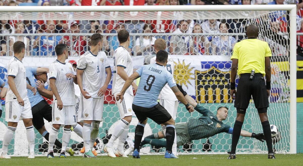 Uruguay's Luis Suarez scores his side's first goal Monday against Russia.
