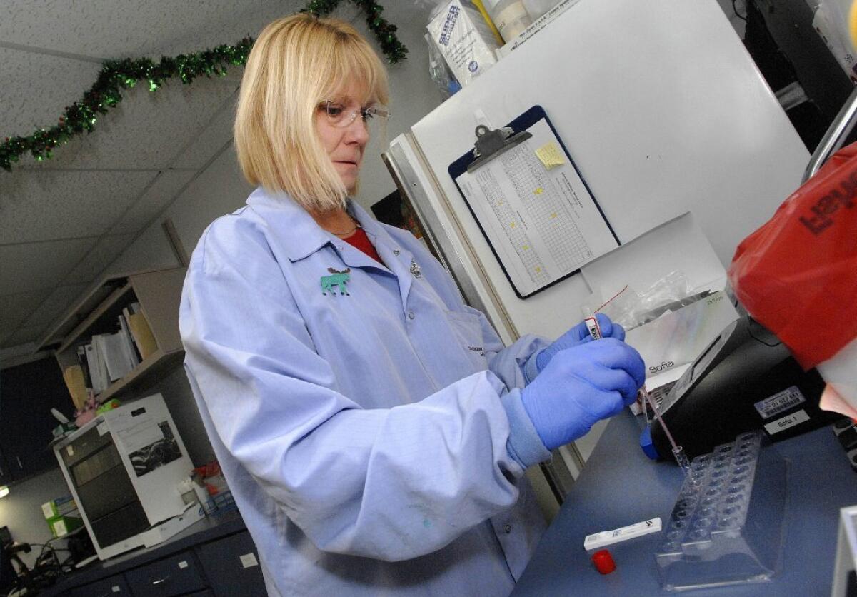 Sue Carroll tests a sample of patient fluids for signs of influenza in the laboratory at Advocate BroMenn Regional Medical Center in Normal, Ill. New data from the CDC show that flu activity is widespread in Illinois and 35 other states.