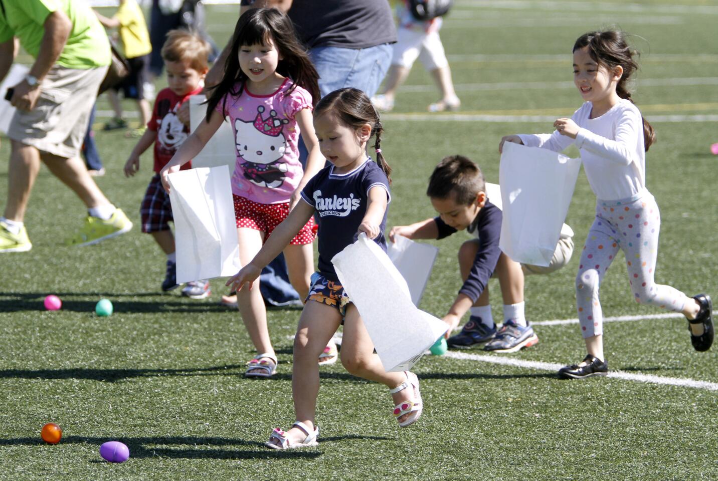 Allyson Oliver, 3 of Glendale, gets to a couple of Easter eggs before others grab them at the City of Glendale Parks & Recreation's Easter Egg Hunt at Pacific Community Center in Glendale on Saturday, March 28, 2015.