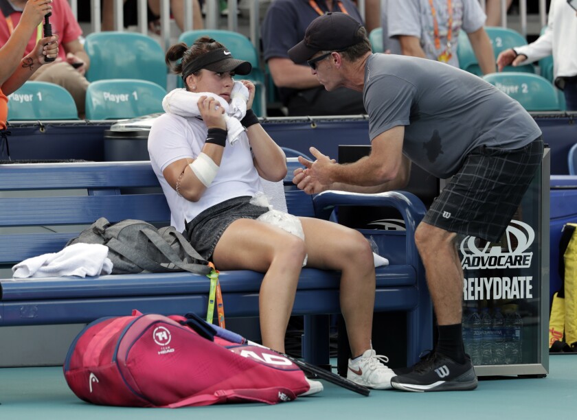 FILE - In this March 21, 2019 file photo, Bianca Andreescu, of Canada, left, talks with her coach Sylvain Bruneau during her match against Irina Camelia Begu, of Romania, at the Miami Open tennis tournament in Miami Gardens, Fla. Bruneau has released a statement, Sunday, Jan. 17, 2021, saying he was the positive coronavirus case aboard the flight from Abu Dhabi to Melbourne and he had followed all protocols and procedures, including producing a negative test within 72 hours before the flight departure and has "no idea how I might have contracted the virus." (AP Photo/Lynne Sladky, File)