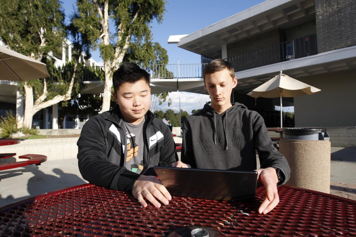 Editor-in-chief Ethan Kim, 16, left, and contributor Mason Pirkey, 16, right, talk about The Outspoken Oppa website, at La Canada High School in La Canada Flintridge on Thursday, Jan. 9, 2020. Both are juniors at the school.