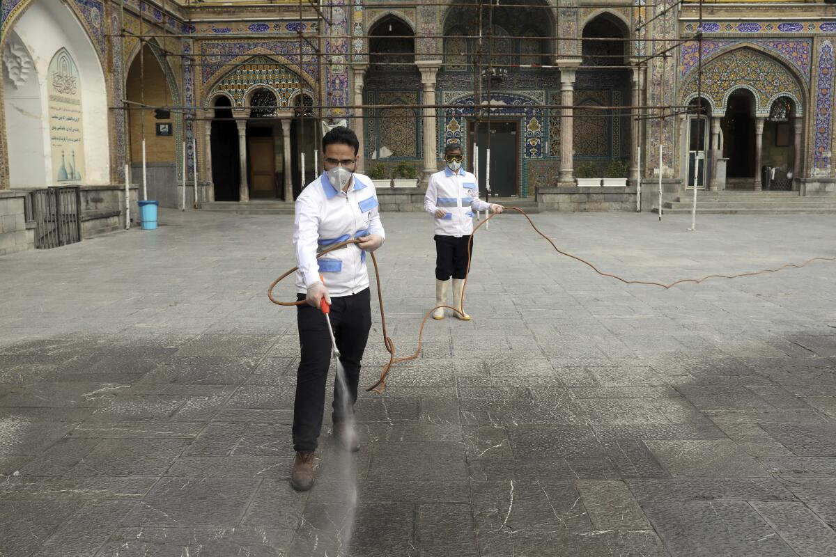 Trabajadores desinfectando el santuario del imán Abdulazim, un santo chií, para ayudar a evitar la expansión de un nuevo coronavirus, en Shahr-e-Ray, al sur de Teherán, Irán, el sábado 7 de marzo de 2020. (AP Foto/Ebrahim Noroozi)