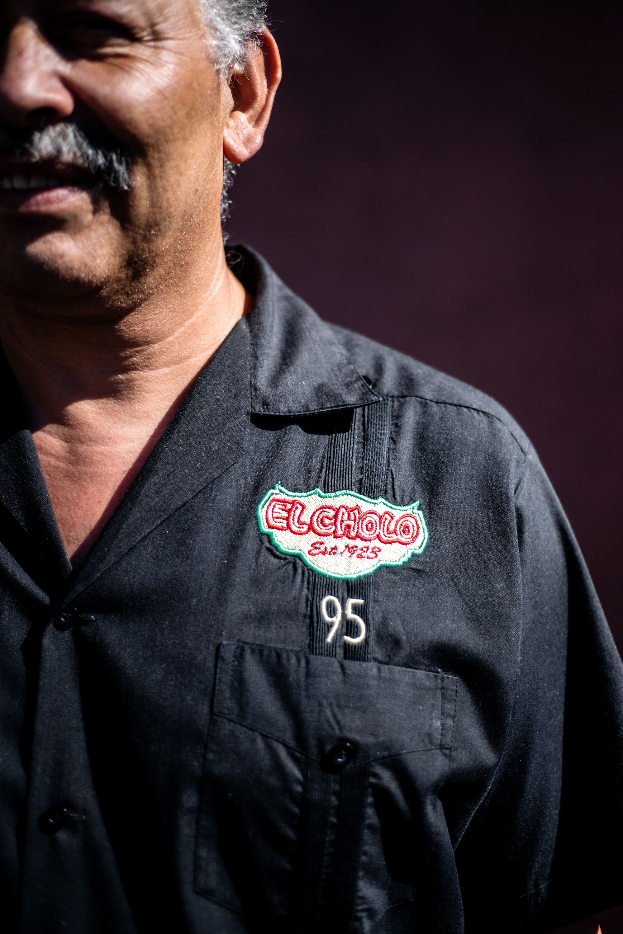 A close up of  Jaime Cornelio's shirt, which reads "El Cholo, est. 1923, 95"