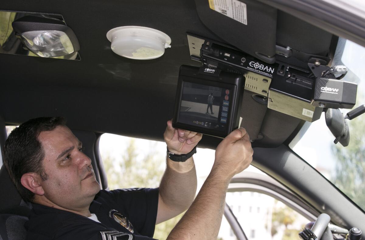 Los Angeles Police Sgt. Dan Gomez, a department expert on recording devices, shows a video display inside a patrol car with a camera pointed through the windshield at right. LAPD officers tampered with recording gear in dozens of patrol cars to avoid being monitored, and avoided discipline for the altered cars, The Los Angeles Times reported Tuesday.
