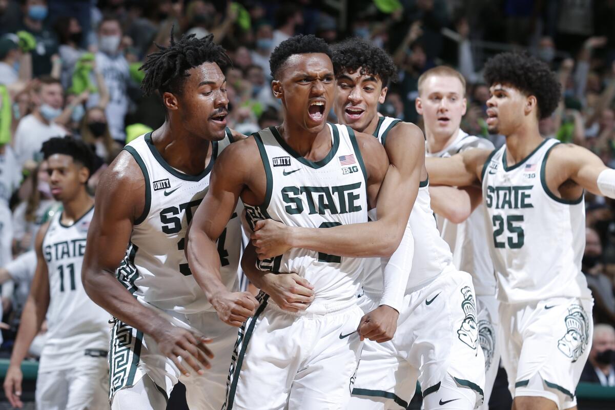 Michigan State's Tyson Walker (2), middle, and teammates are pumped up in an upset of Purdue.