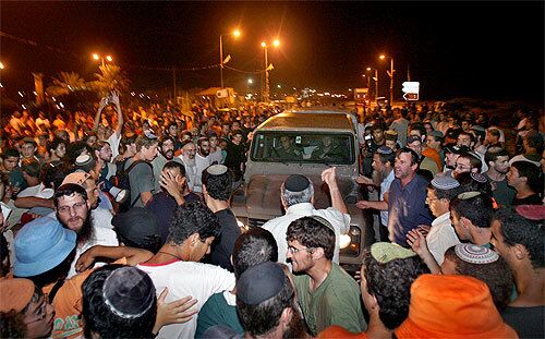 Protesters bar an Israeli army jeep from entering the Jewish settlement of Neve Dekalim in Gaza today. The army said troops would refrain for now from going into five settlements where residents had made clear that soldiers were unwelcome.