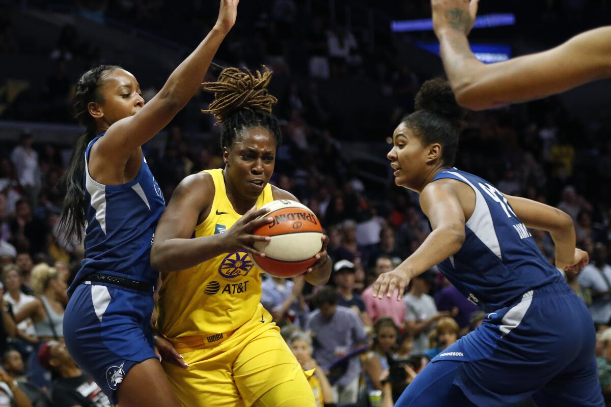 Sparks guard Chelsea Gray drives between the Lynx's Lexie Brown, right, and Damiris Dantas during a game last season.