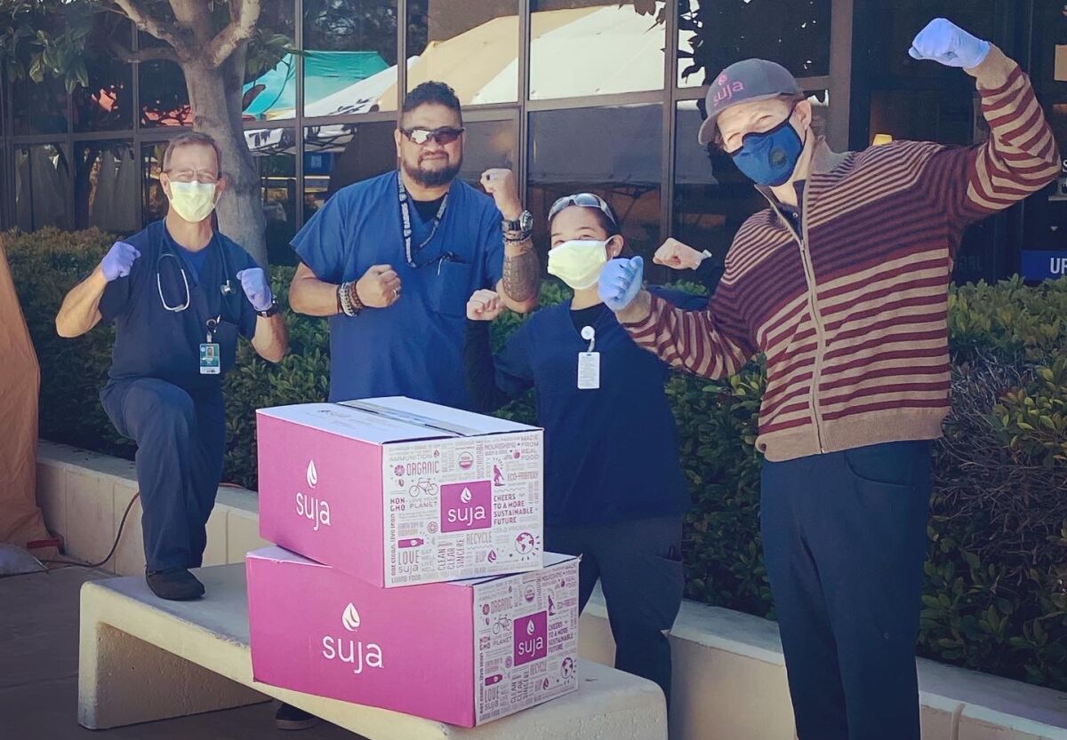 Suja Juice co-founder James Brennan (right) delivers cases of fruit and vegetable juice to hospital staffers at Scripps Hospital.