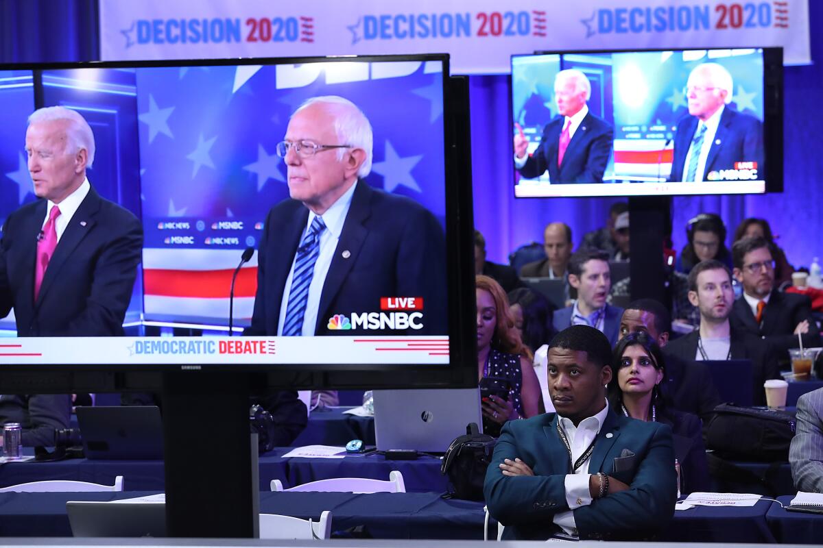 Democratic presidential candidates former Vice President Joe Biden, left, and Sen. Bernie Sanders of Vermont are seen being broadcast on television monitors in the media room during the Democratic presidential debate on Wednesday in Atlanta.