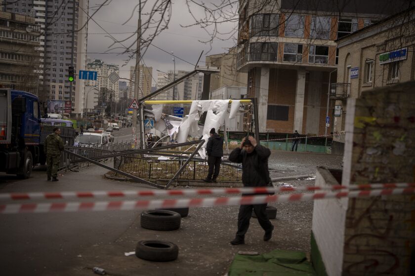 Policías inspeccionan una zona en Kiev, Ucrania, después de un aparente ataque ruso el jueves 24 de febrero de 2022. (AP Foto/Emilio Morenatti)