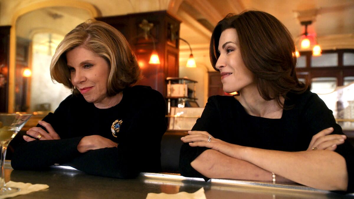 Two women sit at a bar, smiling 