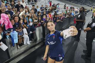 A woman takes a selfie with fans