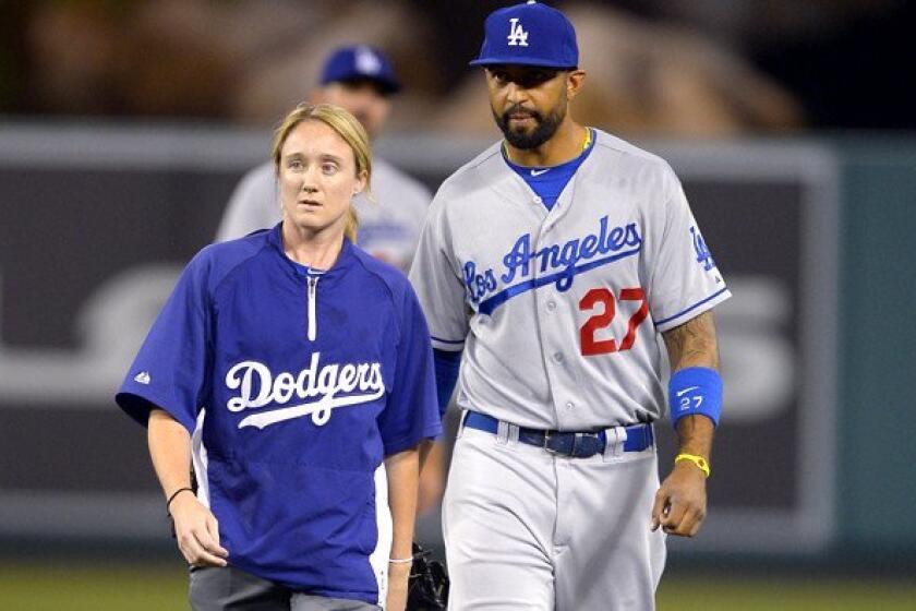Dodgers center fielder Matt Kemp walks off the field with assistant trainer Nancy Patterson during the seventh inning of Wednesday night's game in Anaheim.