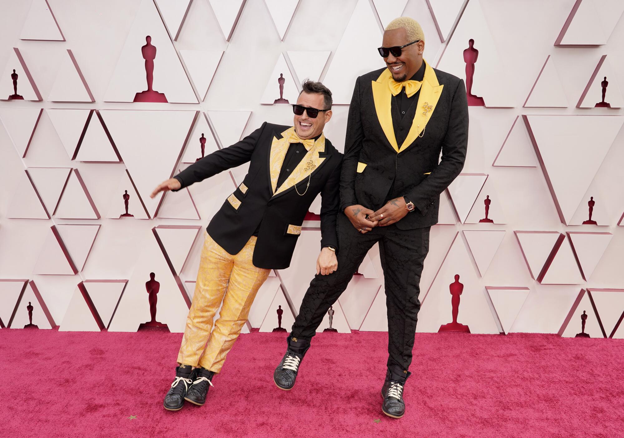 Martin Desmond Roe, left, and Travon Free in yellow and black suits on the red carpet.