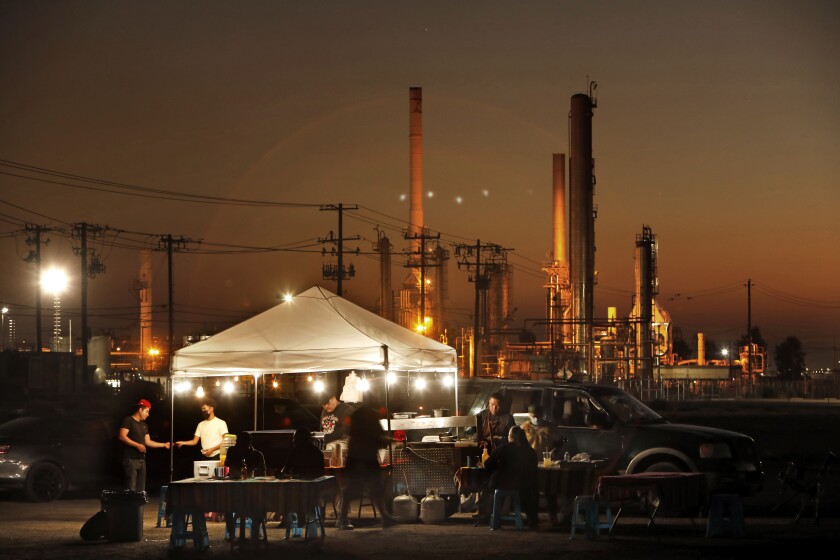 A taco stand operates near the Kern Oil & Refining Co. facility in Lamont, Calif.