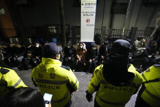 Police officers stand in front of supporters of impeached South Korean President Yoon Suk Yeol.