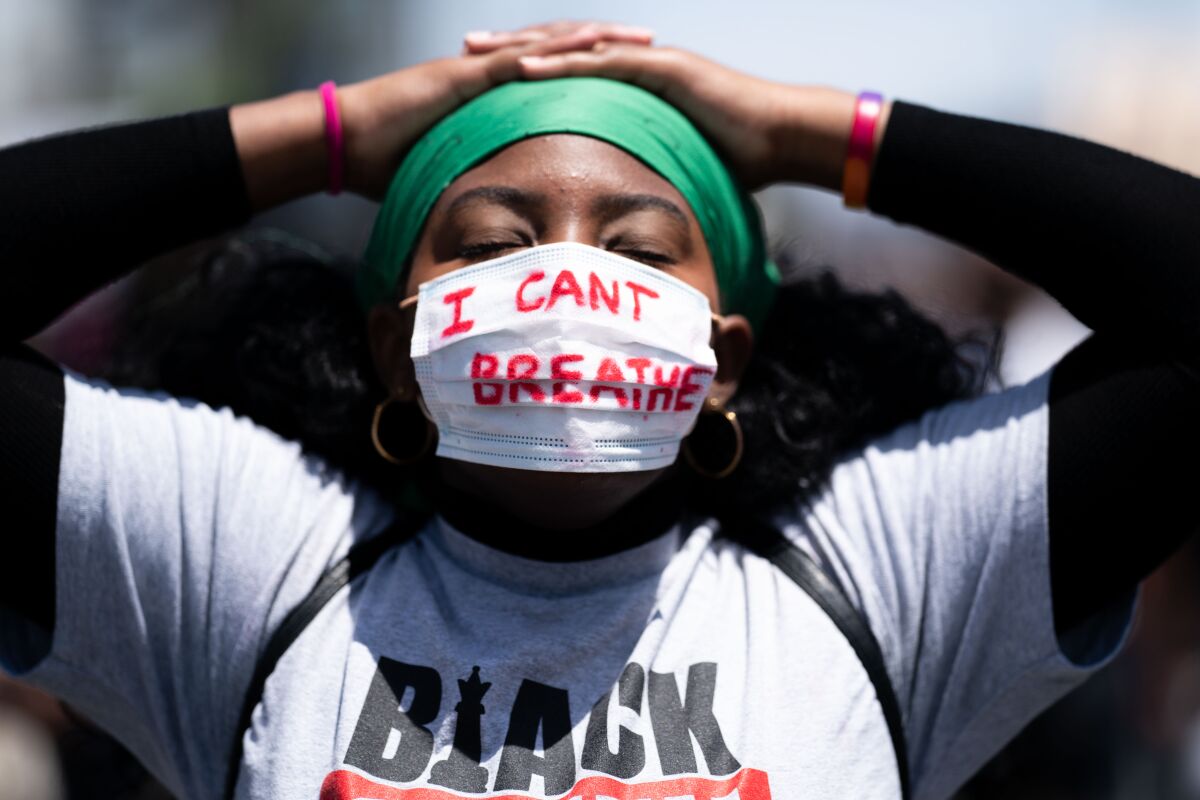 A protester wears a face mask with the words "I can't breathe."