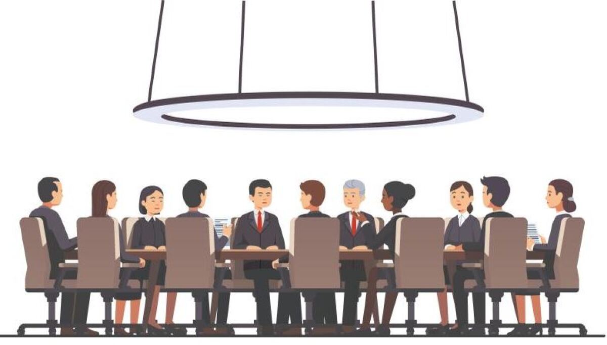 Men and women sit around a conference table.