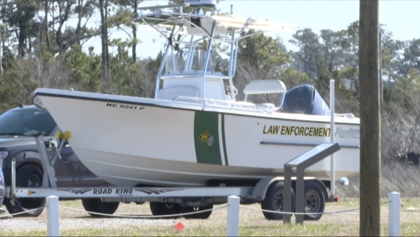 Law enforcement get ready for a search after a small plane crash in Carteret County, N.C., on Monday, Feb. 14, 2022. Authorities say four teenagers and four adults returning from a hunting trip were on board a small plane that crashed off the coast of North Carolina over the weekend. (WCTI-TV via AP)
