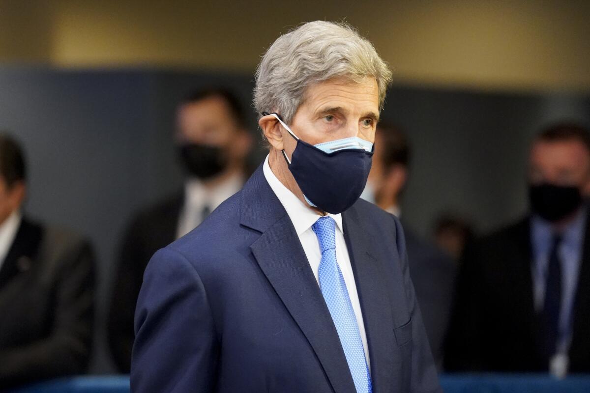 John Kerry in a suit and two face masks