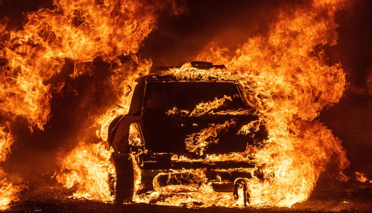 A car burns while parked at a residence in Vacaville, California during the LNU Lightning Complex fire on August 19, 2020. -