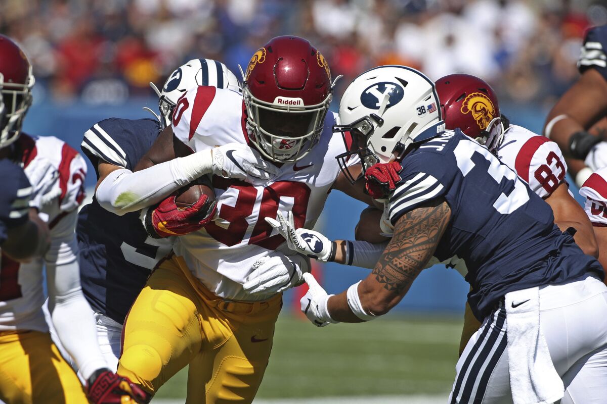 USC running back Markese Stepp tries to push past BYU linebackers Jackson Kaufusi, right, and Max Tooley during the first half.