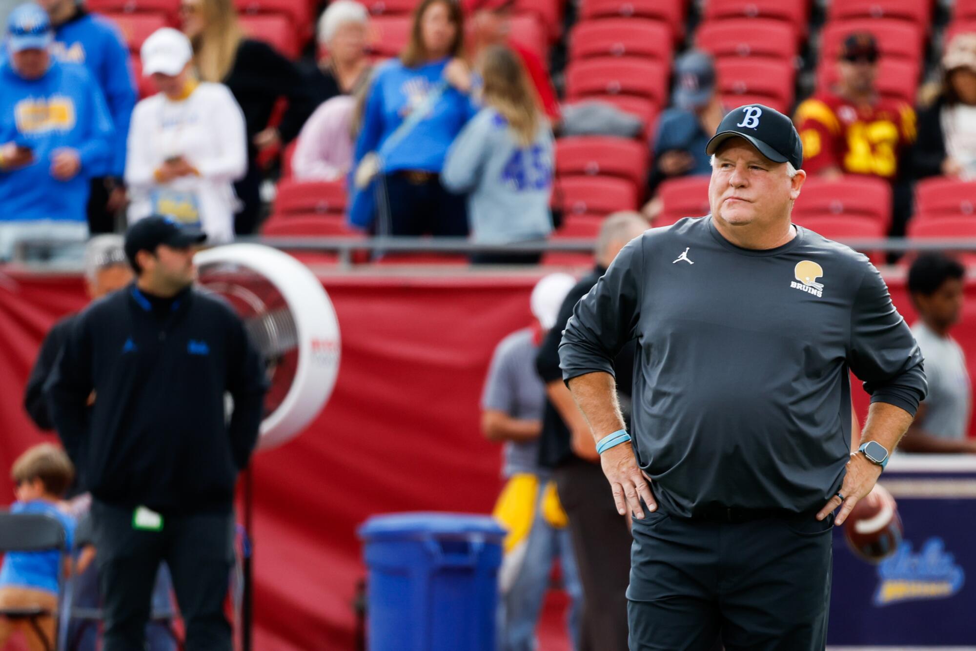 UCLA antrenörü Chip Kelly, Cumartesi günü Coliseum'da USC'ye karşı oynanan maç öncesinde ısınma hareketlerini izliyor.