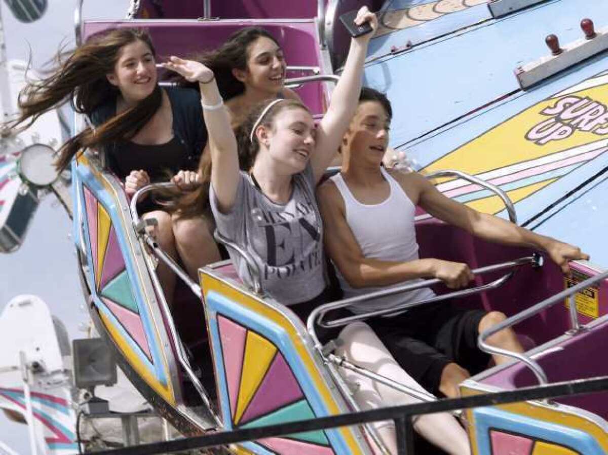 Ana Goodenberger, 16, of La Crescenta, front left, and Miles Parsons, 13 of Montrose, enjoy a ride on The Tidal Wave ride at the Montrose 35th Annual Oktoberfest on Honolulu Ave. in Montrose.