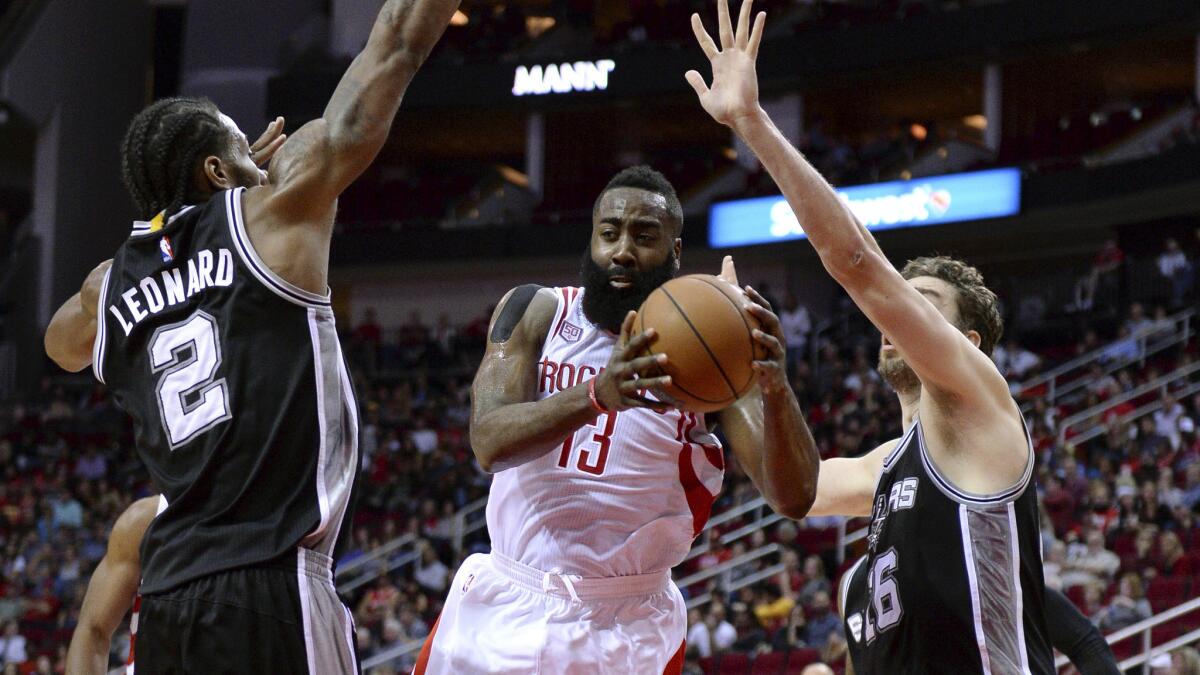 Spurs forwards Kawhi Leonard and Pau Gasol try to cut off a drive by Rockets guard James Harden during their game Saturday night.