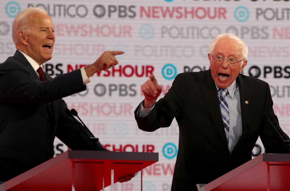 Former Vice President Joe Biden and Sen. Bernie Sanders argue during the Democratic presidential primary debate at Loyola Marymount University on Dec. 19 in Los Angeles.
