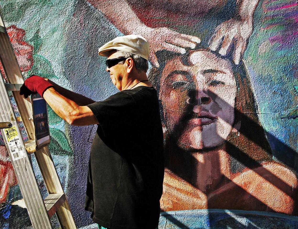 Los Angeles' murals -- a rich legacy on display in the open air -- are endangered by graffiti and the elements. Ernesto de la Loza sets up his materials as he races to clean and stabilize his "Resurrection of the Green Planet," a 1991 creation on the wall of a convenience store at Cesar E. Chavez Avenue and Breed Street in Boyle Heights.