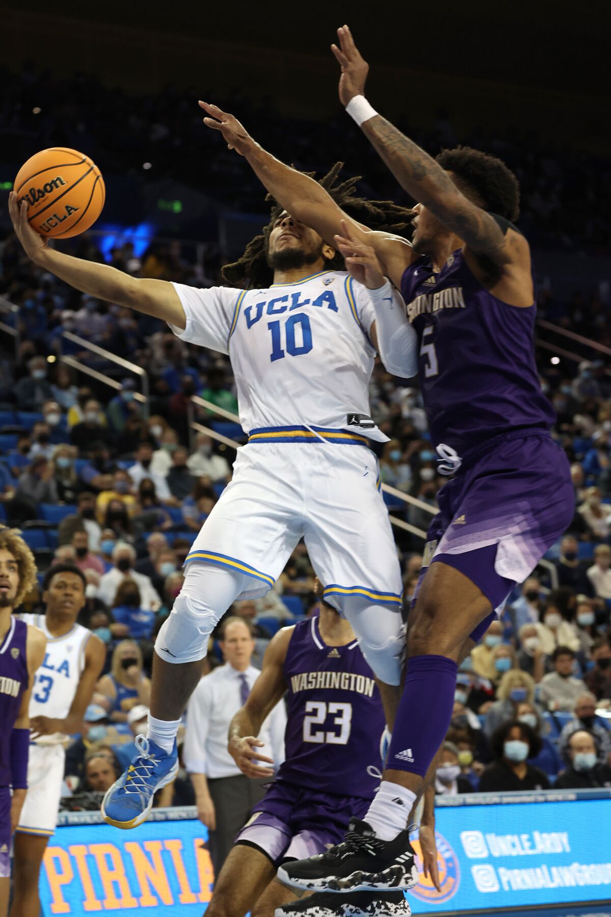 UCLA's Tyger Campbell goes up for a shot against Washington's Jamal Bey.