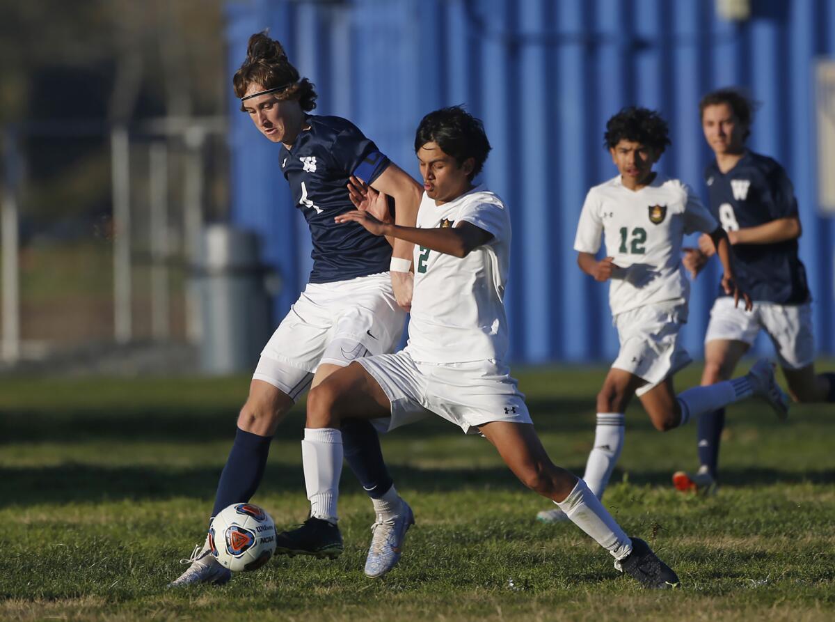 Jamie Eijpen (4) of Waldorf School battles Rancho Alamitos defender Axel Escamilla (2) in the CIF Division 7 wildcard game.